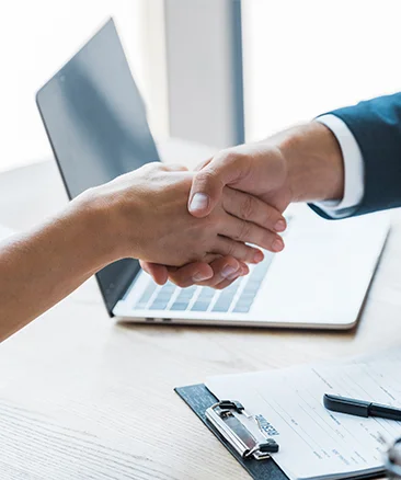 hr officer shaking hands near laptop opened with hr software